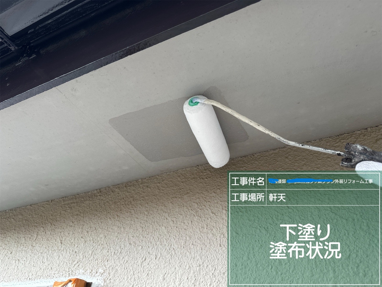 軒天に下塗りしている様子