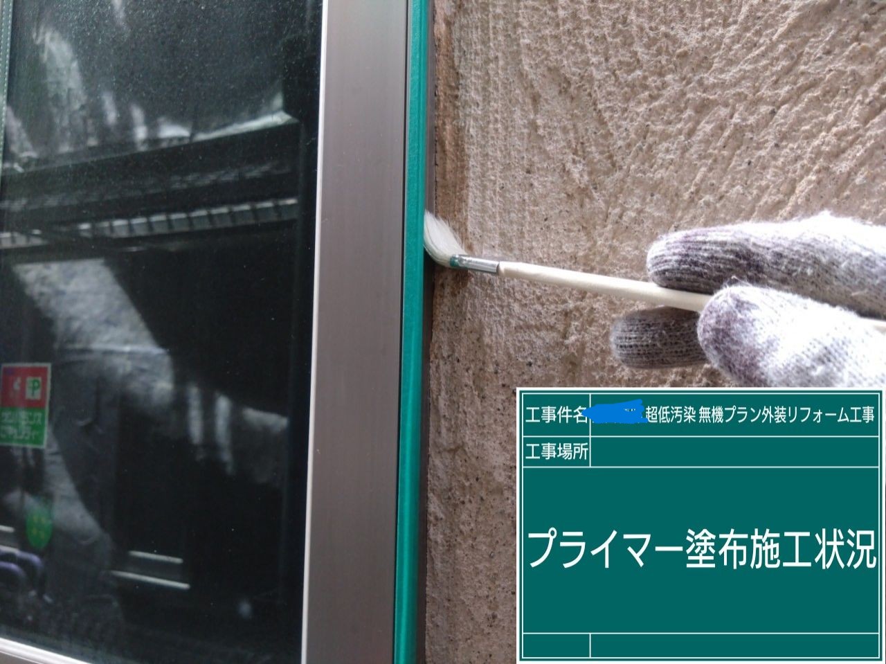 窓のサッシ部分に刷毛でプライマーを塗布している様子