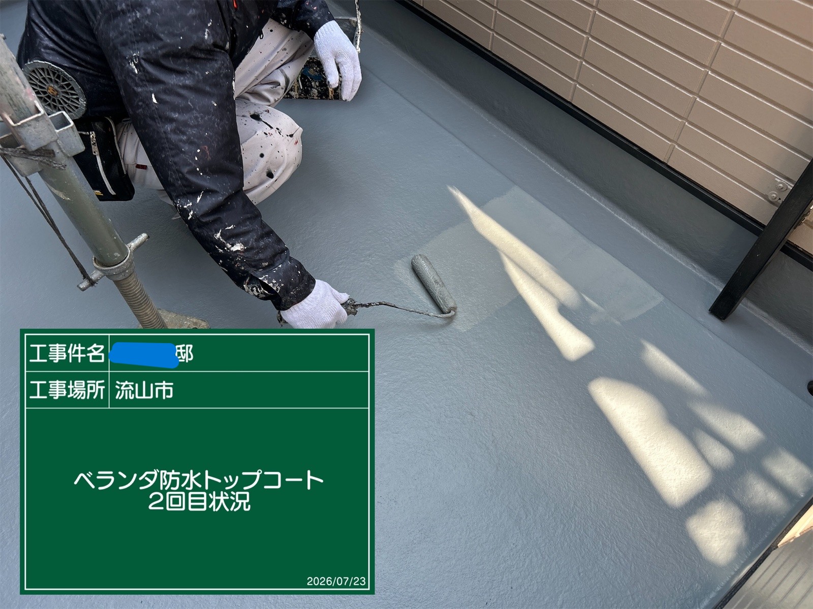 ベランダにローラーでトップコートを塗布する様子
